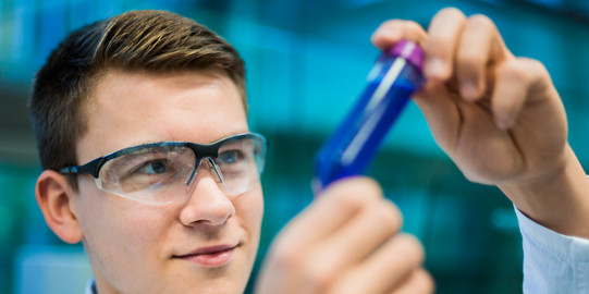 A researcher holds a sample vessel in his hand.