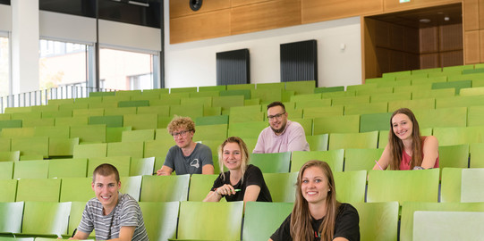 A group of students are sitting in a lecture hall.